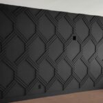 Black wall with a contemporary geometric pattern of raised intersecting lines.