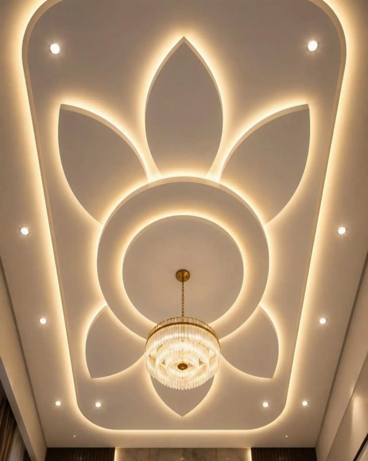 White POP ceiling with a glowing lotus design and a crystal chandelier.